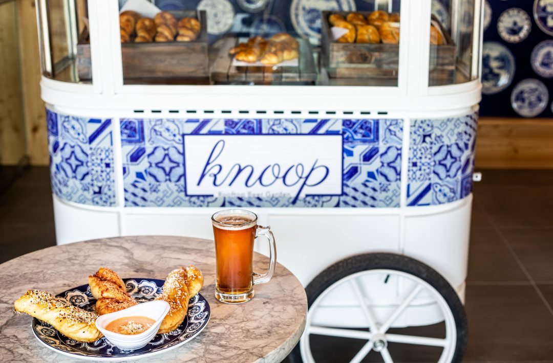 Table with bread and beer in front of cart with Knoop logo